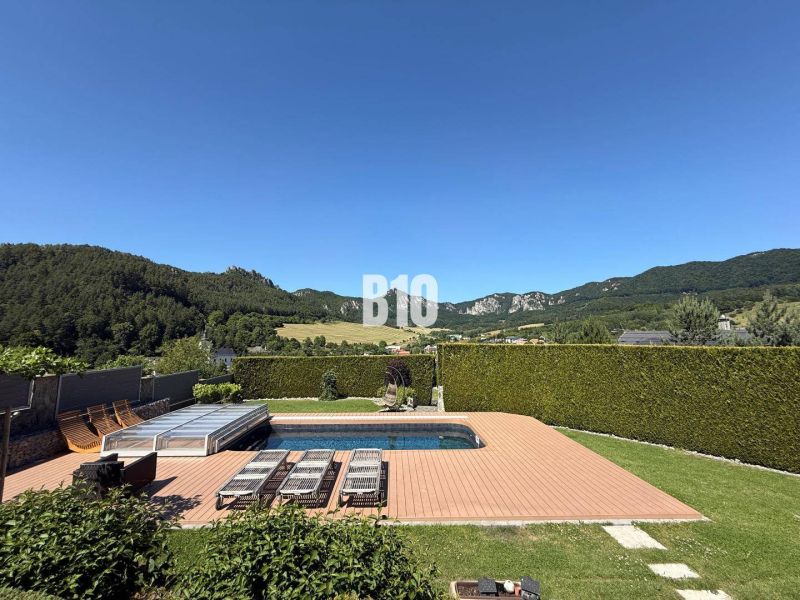 Eine Villa in Súľov-Hradná mit einem Pool auf der Holzterrasse, umgeben von wunderschöner Natur.