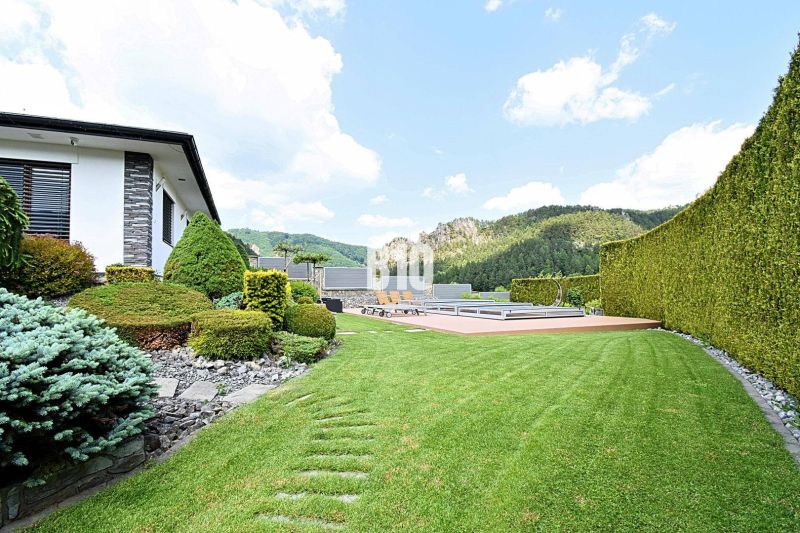 Der Garten der Villa in Súľov-Hradná mit gepflegtem Rasen und Blick auf die Berge.