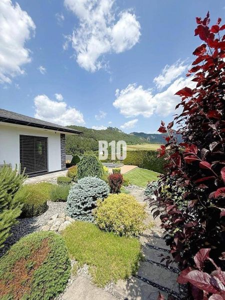 Das Äußere der Villa in Súľov-Hradná mit einem schönen Garten und einem Panoramablick auf die Berge.