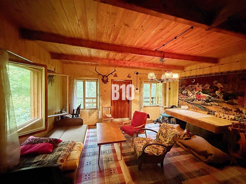 Das Innere der Hütte mit einer Holzdecke, bequemen Sitzgelegenheiten und einem dekorativen Teppich an der Wand.