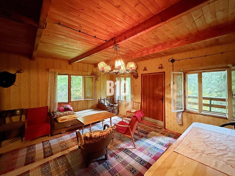 Rustikales Interieur einer Hütte mit komfortablen Möbeln und einem Boden mit Holzdekor.