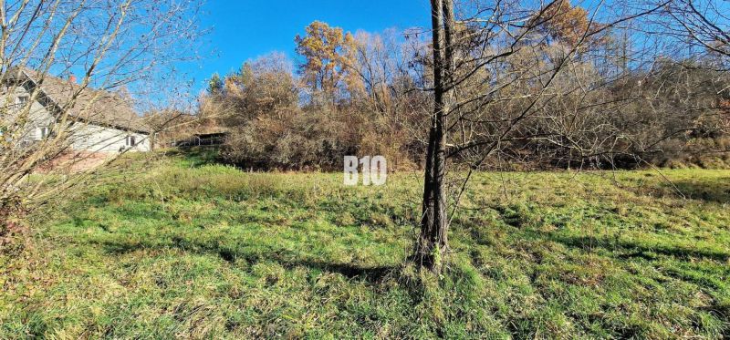 Großzügige Wohnbaugrundstücke in Bytča, umgeben von Bäumen, mit einer Immobilie im Hintergrund.