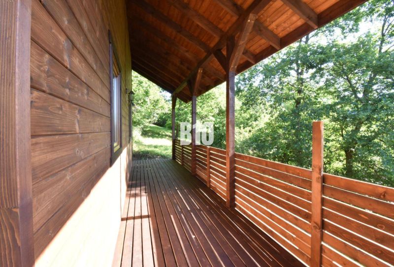 Die Holzterrasse der Hütte in Bytča, umgeben von Grün und Waldlandschaft.
