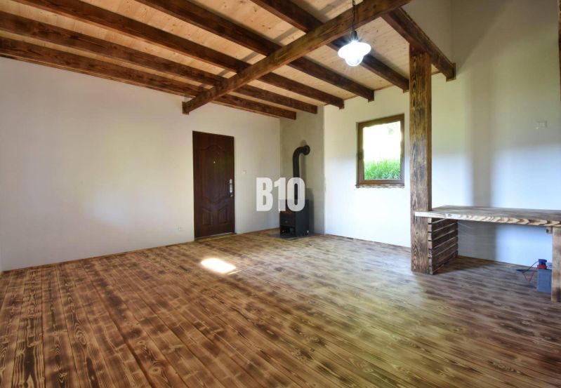 Interieur einer Hütte mit Holzdecke, Holzboden und Ofen.