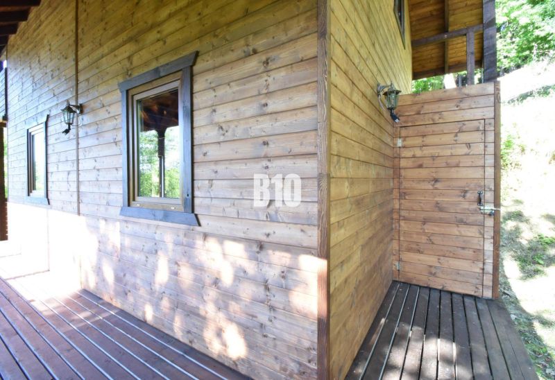 Eine Holzhütte mit Terrasse in Bytča, umgeben von Natur und Sonnenlicht.