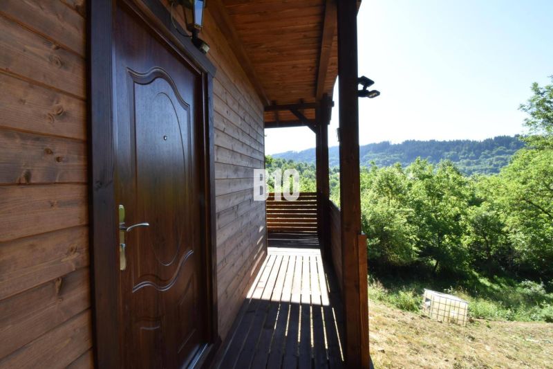 Eine Hütte bei Bytča mit einer Holzterrasse, umgeben von grüner Natur und Wäldern.