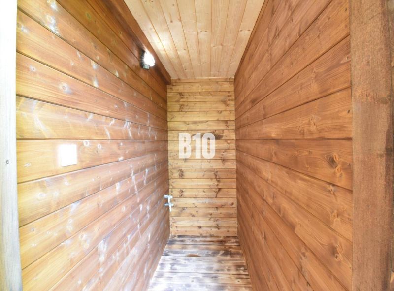 Holzinterieur mit Wandleuchten und Holzboden in einer Hütte.