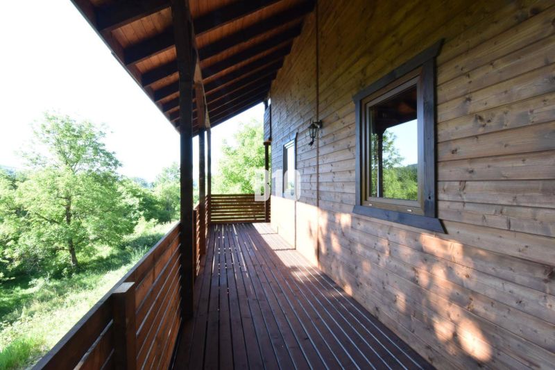 Eine Holzterrasse der Hütte in Bytča mit Blick auf Grünflächen und Wälder.