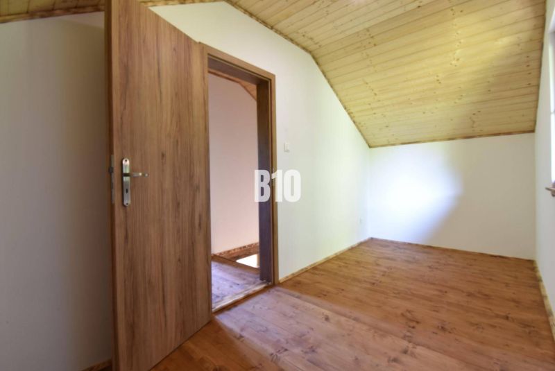 Ein Zimmer in einer Hütte mit Holztüren und Holzboden.