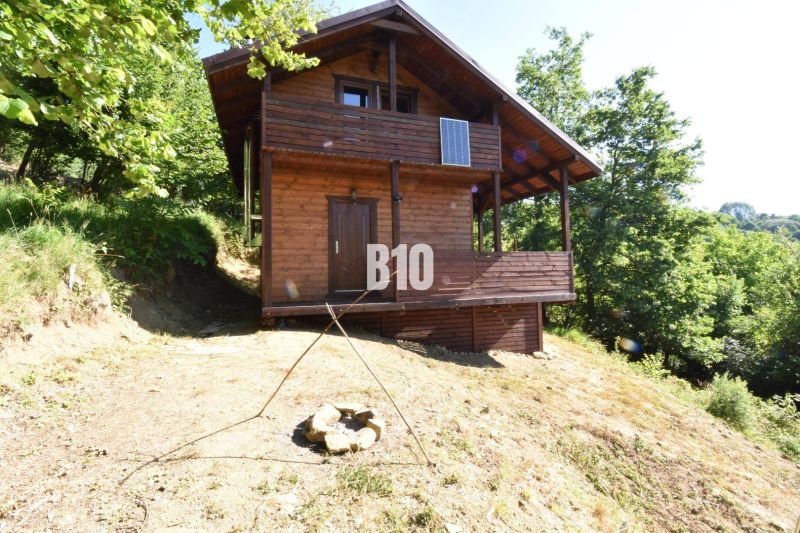 Eine Holzhütte in der Natur bei Bytča, umgeben von Bäumen und einer Feuerstelle.