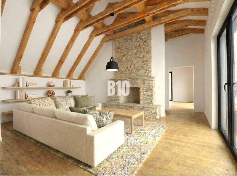 Innenraum einer Hütte mit Kamin, Sofa und Holzboden.