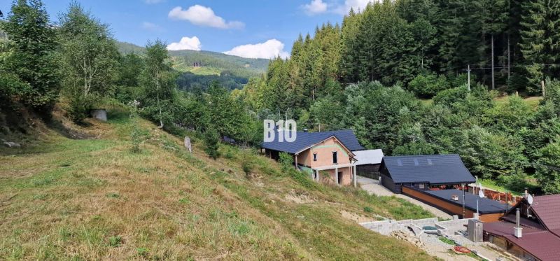 Ein Einfamilienhaus im Tal, umgeben von Wäldern und Hügeln. Eine reizvolle Naturlandschaft.
