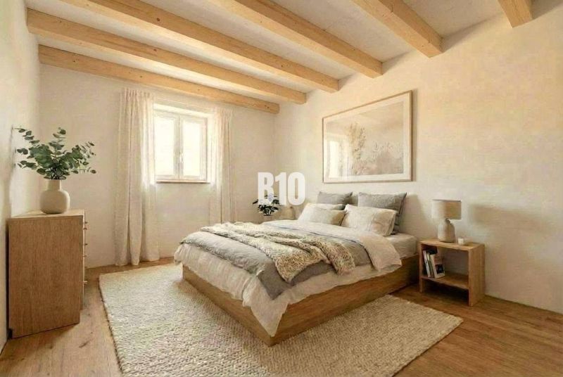 Das Innere der Hütte mit Holzbalken, einem bequemen Bett und einem Boden mit Holzdekor.