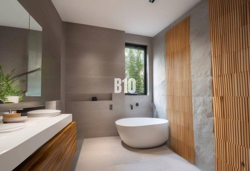 Ein Badezimmer in einer Hütte mit freistehender Badewanne, Holzelementen und einem großen Fenster.