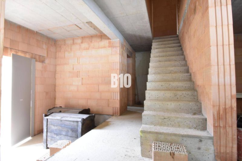 Innenraum der Immobilie eines im Bau befindlichen Einfamilienhauses mit Treppe und Ziegeln für den Bau.