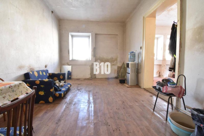 Wohnzimmer in einem Einfamilienhaus mit Holzboden, älteren Möbeln.