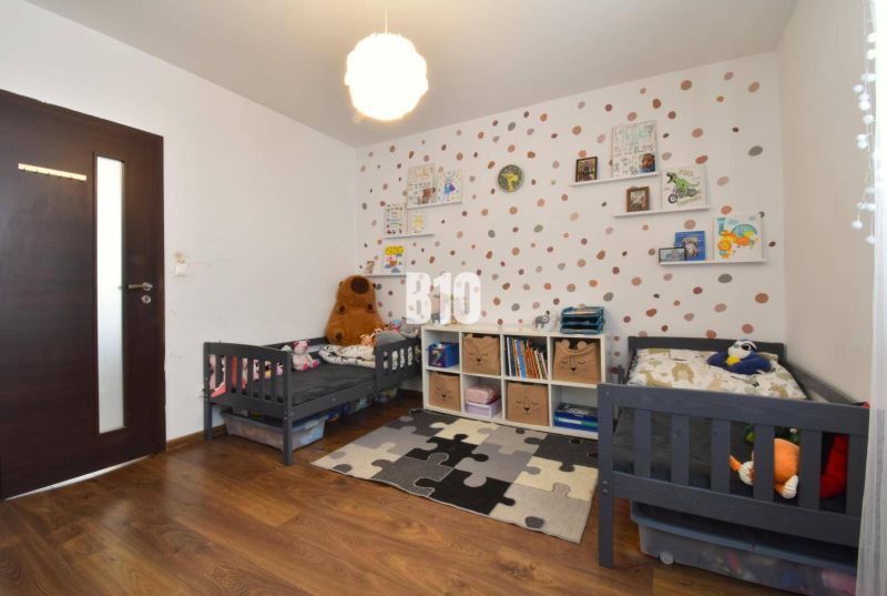 Kinderzimmer mit Kinderbetten, dekorativer Wand und Boden mit Holzdekor in einer 3-Zimmer-Wohnung.