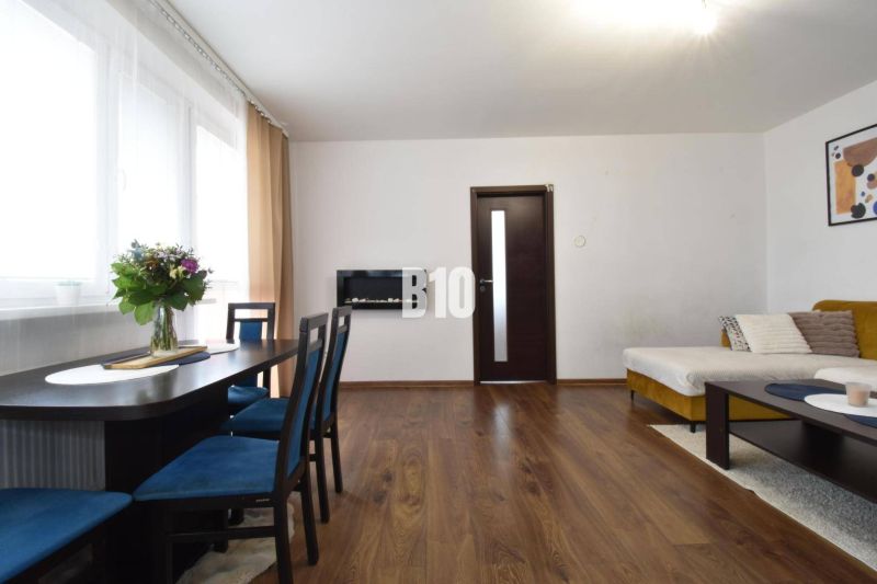 Wohnzimmer in einer 3-Zimmer-Wohnung mit Holzelementen und Esstisch.