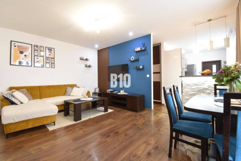 Wohnzimmer in einer 3-Zimmer-Wohnung mit Holzboden und stilvollen Möbeln.