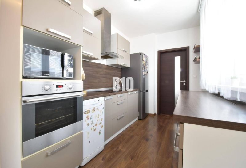 Küche in einer 3-Zimmer-Wohnung mit Holzboden und modernen Geräten.