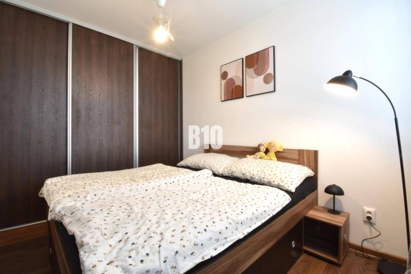 Schlafzimmer in einer 3-Zimmer-Wohnung mit Einbauschrank und Bett mit Holzdekor.