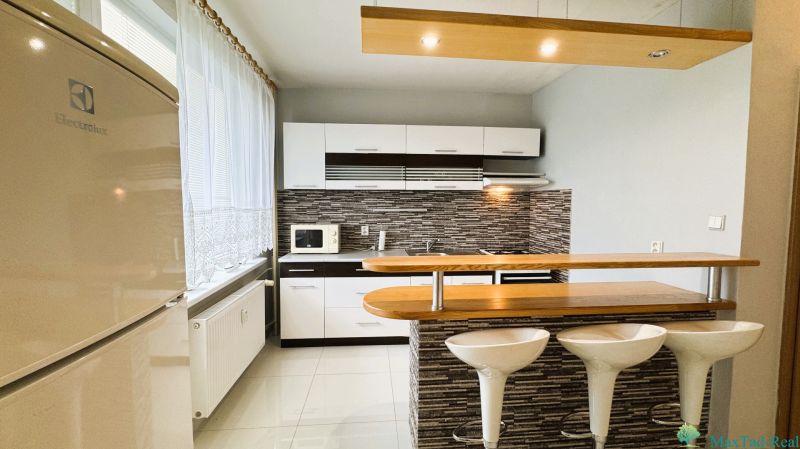 Küche in einer Einzimmerwohnung, helles Interieur, Küchenzeile, Stühle an der Bar.