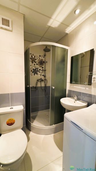 Badezimmer in einer Einzimmerwohnung mit WC, Duschkabine und Waschbecken.