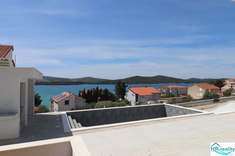 Der Blick von der Villa in Žaborić auf das Meer, die umliegende Landschaft und die Häuser mit roten Dächern.