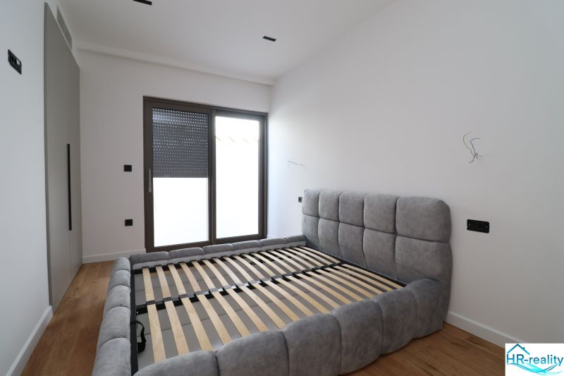Ein Schlafzimmer in einer Villa mit Holzboden und einem geräumigen Bett.