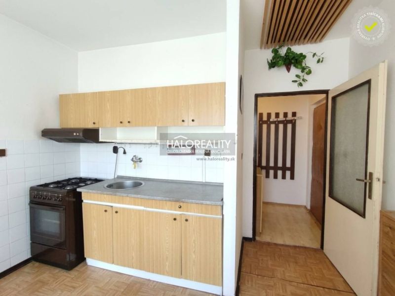 Küche in einer Einzimmerwohnung mit Holzdekor und einfacher Ausstattung.