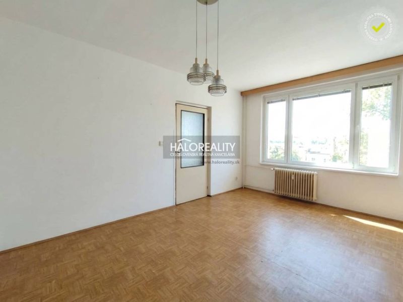 Ein leerer Raum in einer Einzimmerwohnung mit Holzboden und einem großen Fenster.