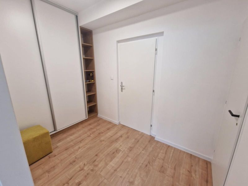 Flur in einer 2-Zimmer-Wohnung mit Holzboden und Einbauschrank.