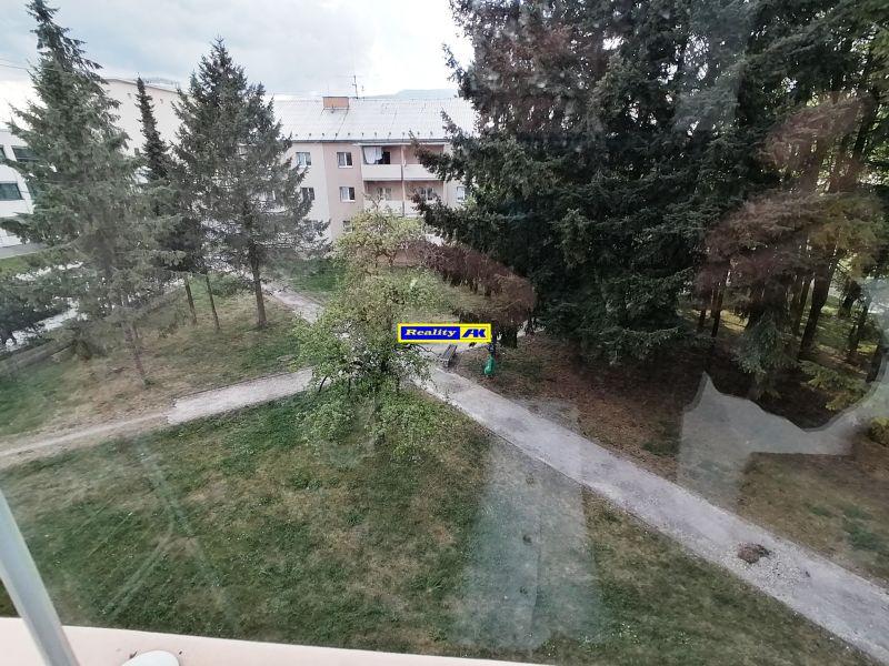 Blick auf das Grün und den Plattenbau von einer Einzimmerwohnung in der Záborského-Straße in Martin.