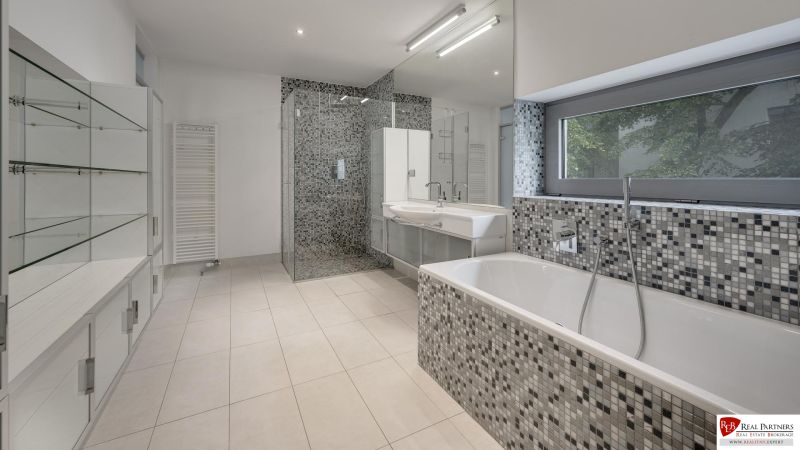 Badezimmer mit Badewanne, Duschkabine und Glasregalen in einer 3-Zimmer-Wohnung.