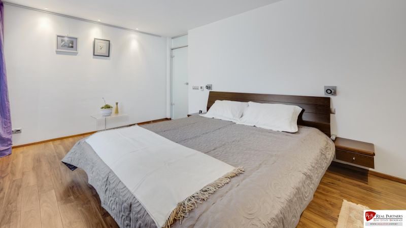 Schlafzimmer in einer 3-Zimmer-Wohnung mit einem bequemen Bett und einem Boden in Holzoptik.