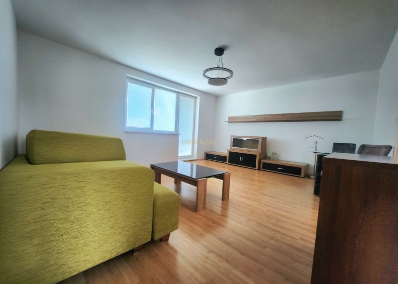 Wohnzimmer mit Sofa, Tisch und Holzboden in einer 3-Zimmer-Wohnung.
