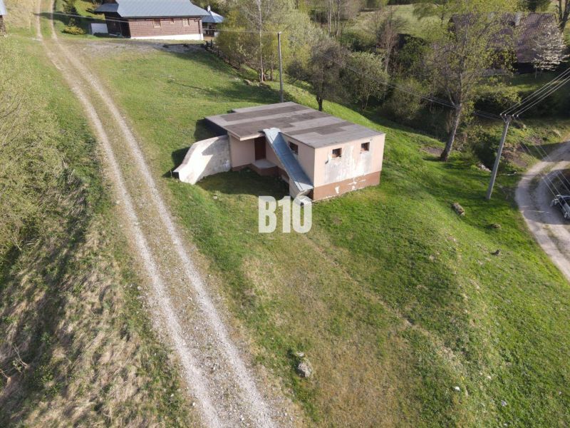 Eine Hütte in Zázrivá, umgeben von grüner Landschaft und einem Feldweg.
