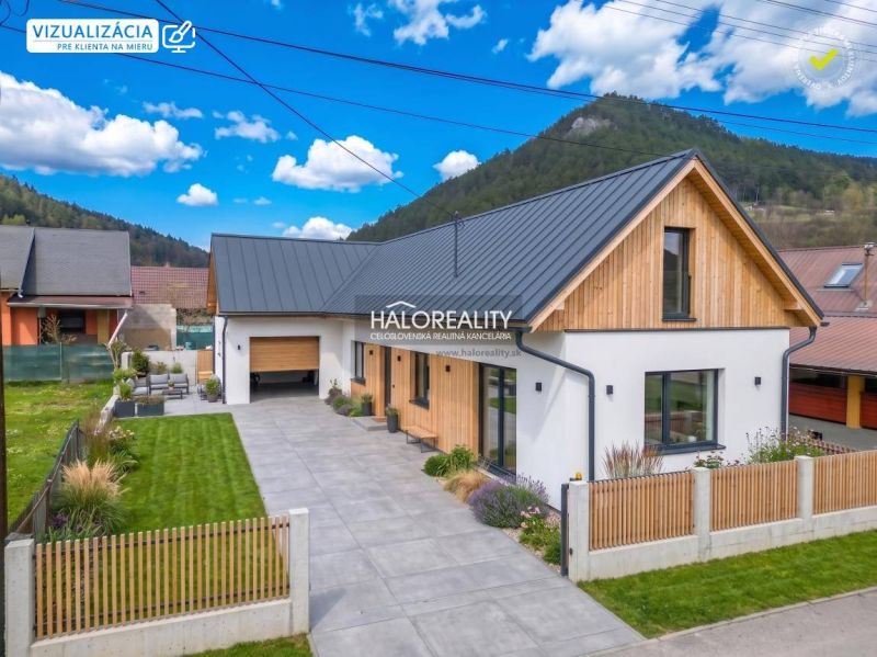 Ein Einfamilienhaus in Stupno mit Garage, gepflegtem Garten und Holzverkleidung an der Fassade.