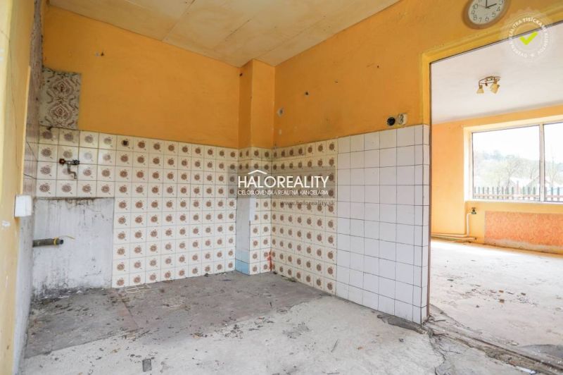 Küche mit orangefarbenen Wänden und gemusterten Fliesen in einem Einfamilienhaus.