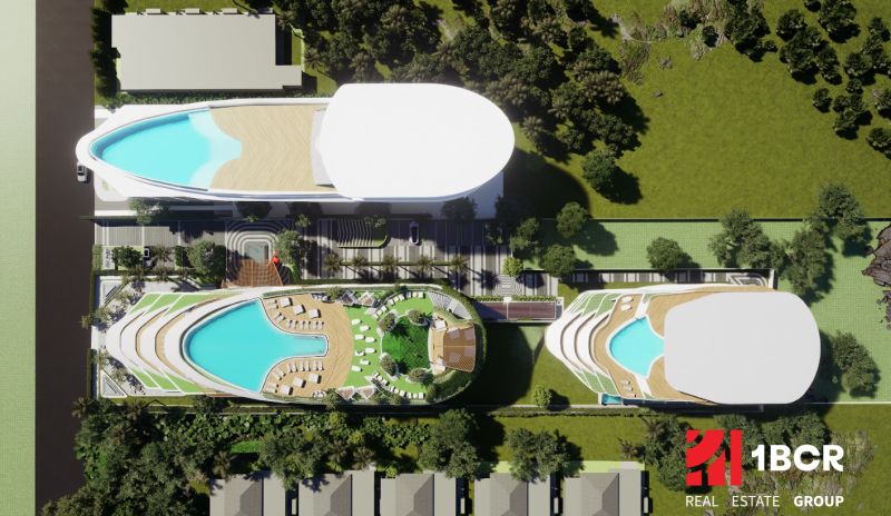 Luftaufnahme des Wohnungsbaus in Phuket mit Dachpools und Grünflächen.