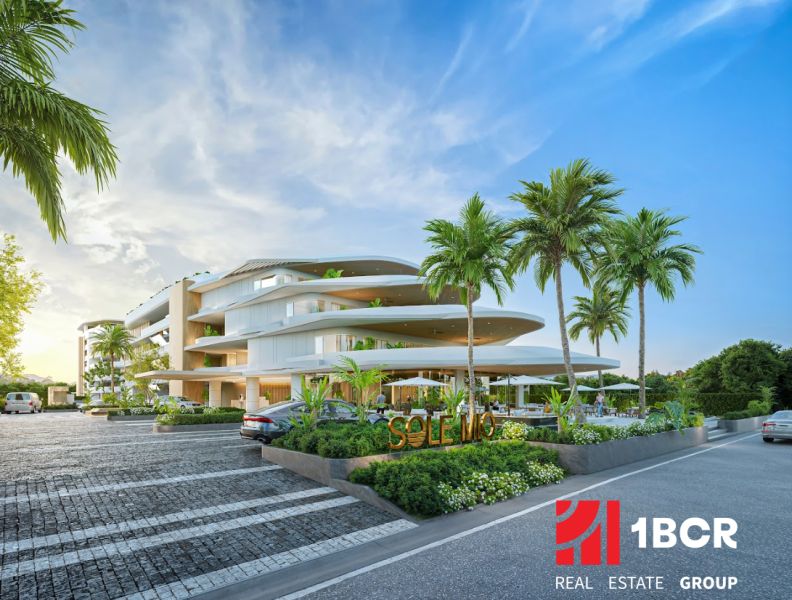 Wohnungsbau in Phuket mit moderner Architektur, umgeben von Palmen und Parkplätzen.