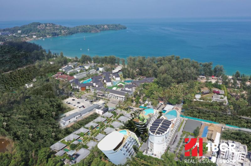 Luftaufnahme des Wohnungsbaus an der Küste von Phuket mit üppigem Grün.