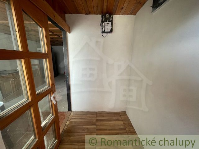 Innenraum mit Holzdecke, Türen mit Glas und Boden mit Holzdekor in einem Einfamilienhaus.