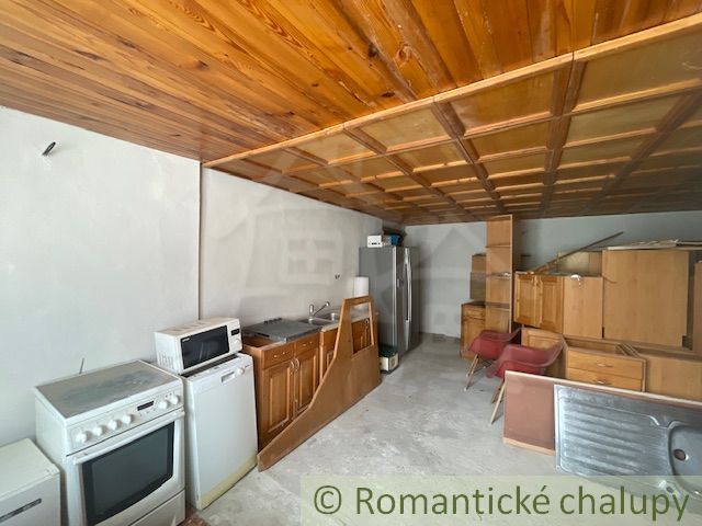 Küche in einem Einfamilienhaus mit Holzbalkendecke und Küchenzeile.