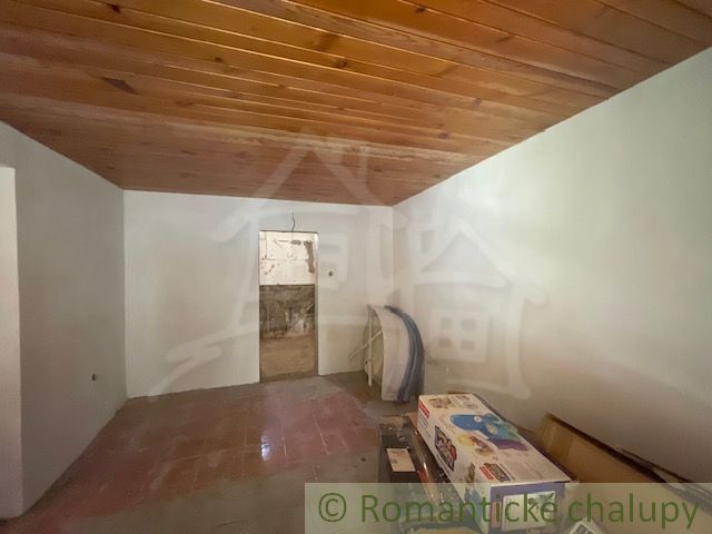 Innenraum eines Einfamilienhauses mit Holzdecke und Fliesenboden.
