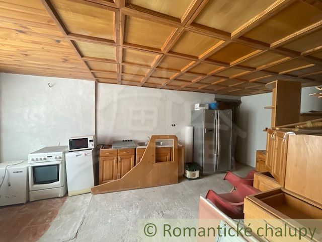 Küchenbereich in einem Einfamilienhaus mit Holzdecke und Geräten.