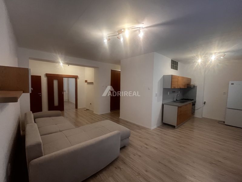 Wohnzimmer in einer 3-Zimmer-Wohnung mit Küche und Holzboden.