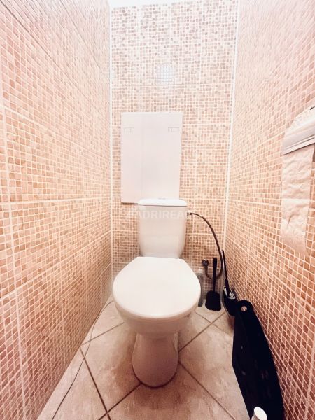 Toilette mit Mosaikfliesen in einer 3-Zimmer-Wohnung, helle und saubere Umgebung.