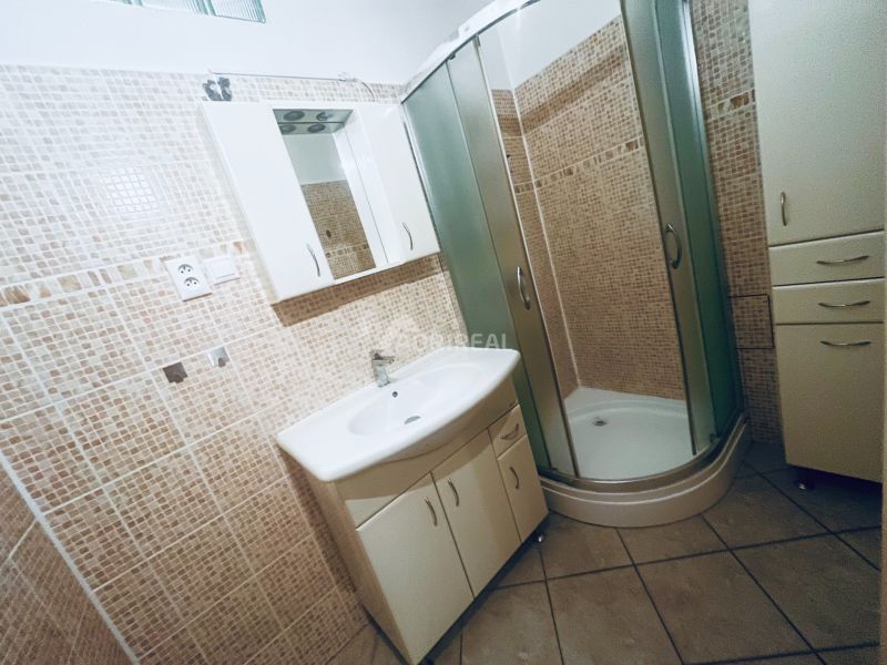 Badezimmer mit Dusche und Mosaikfliesen in einer 3-Zimmer-Wohnung.