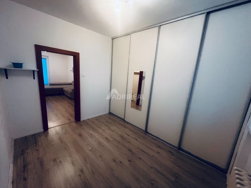Der Flur in der 3-Zimmer-Wohnung mit Schränken und einem Boden in Holzoptik.
